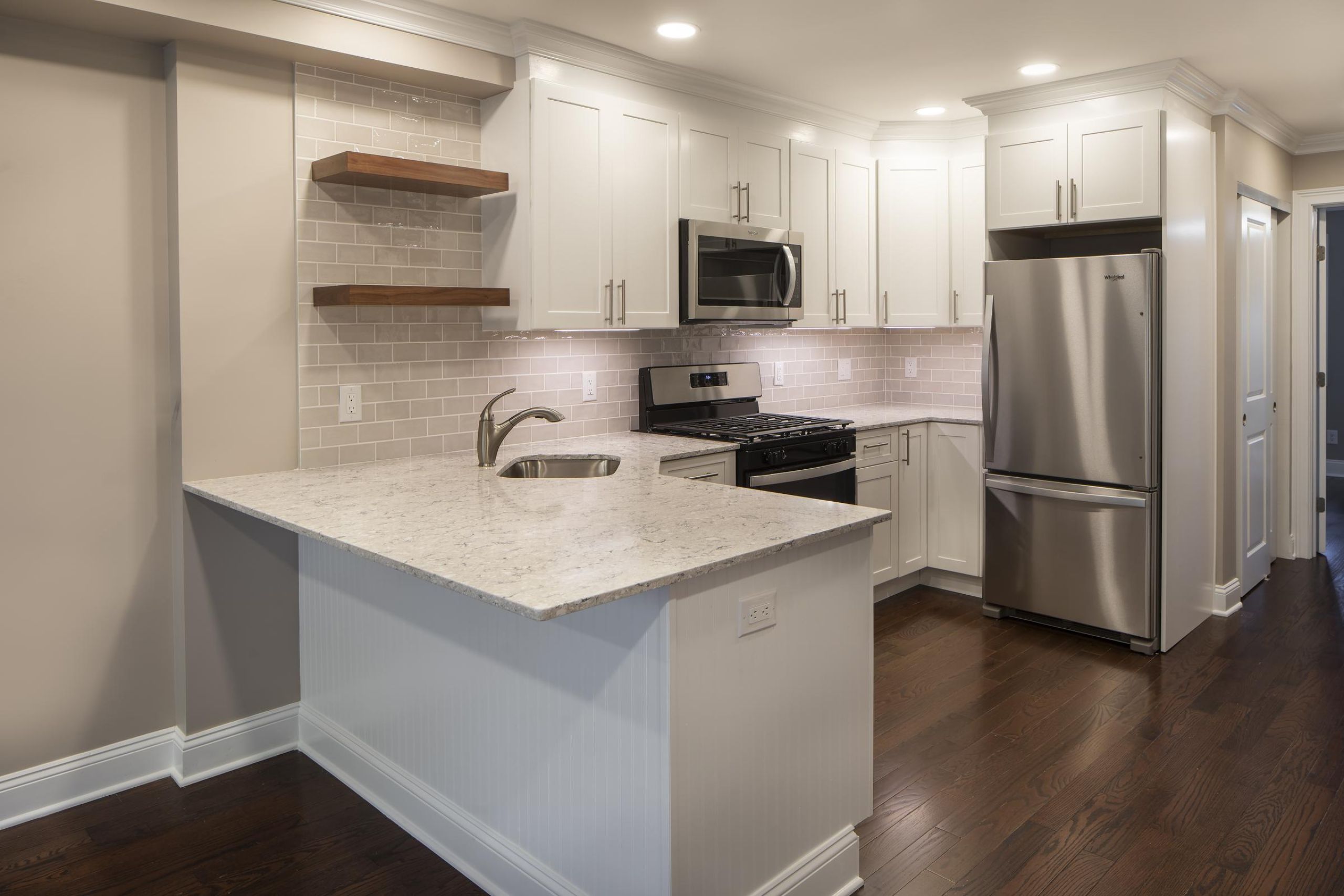 Cambridge ManorPatio with wooden pergola, outdoor seating, chairs, and plants, overlooking a green lawn with flags.