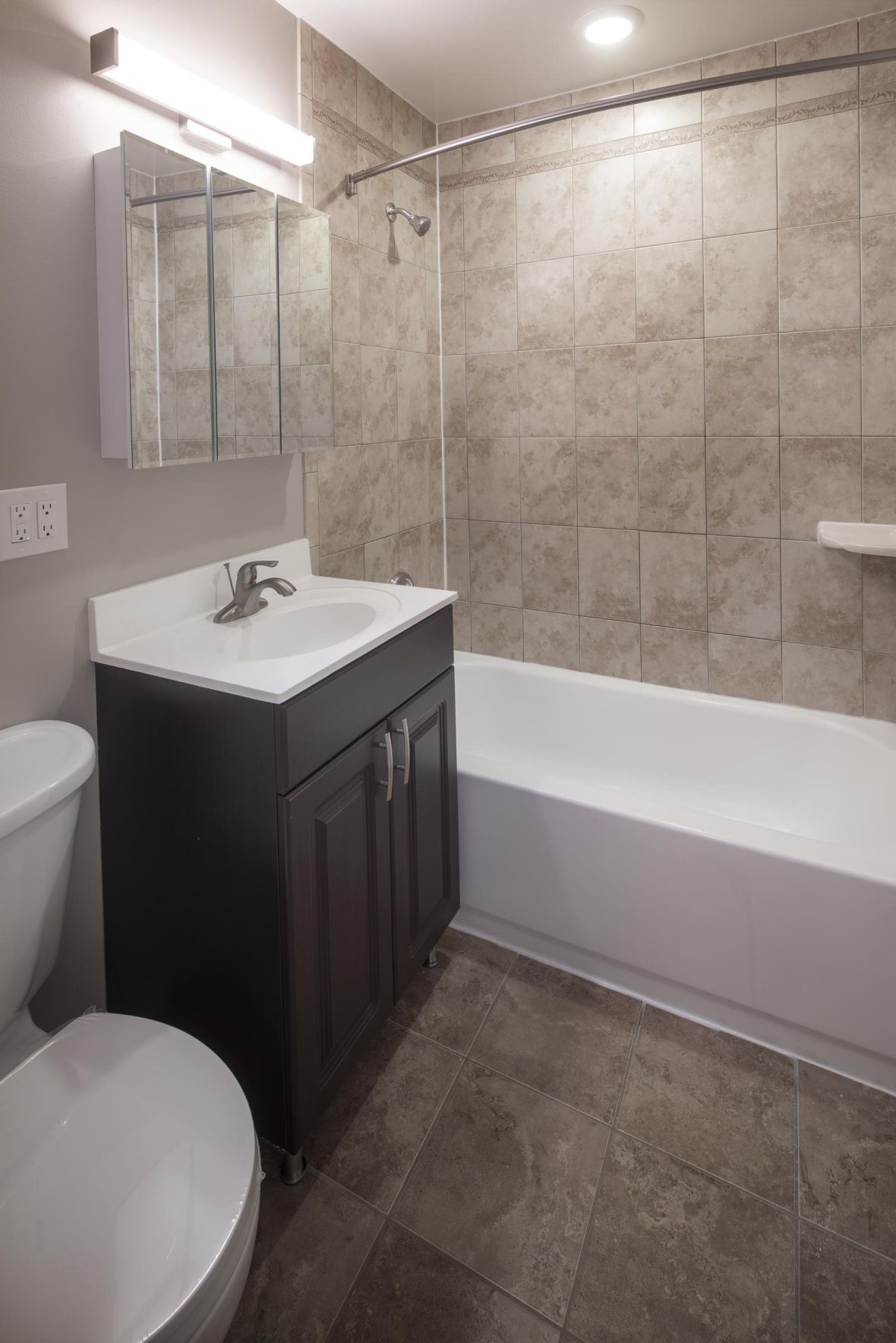 Cambridge Manormodern mid-century furnished bedroom with bed, side table, and round mirror