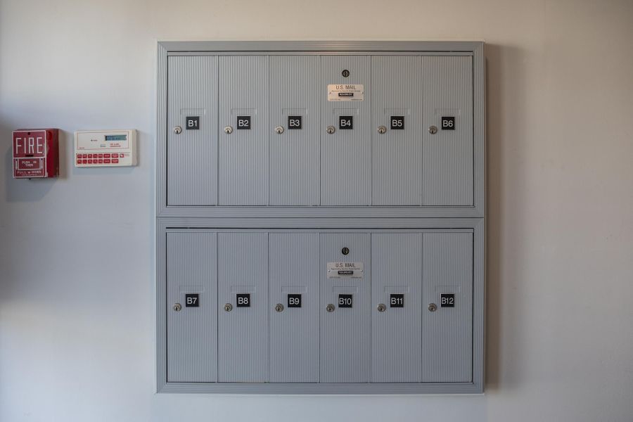 Hickory Manor A modern apartment building with landscaped gardens and a wooden entrance canopy under a partly cloudy sky.