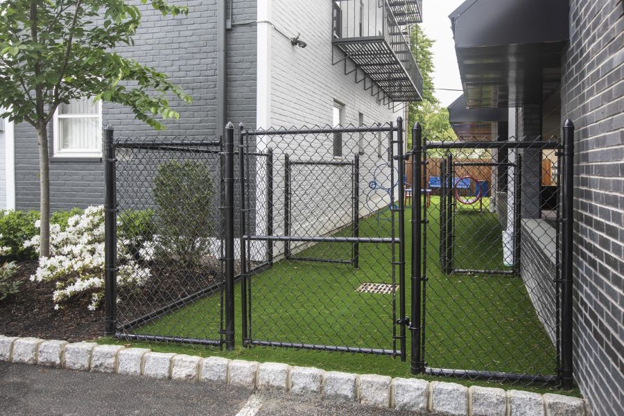 Hickory Manor Two cream chairs and a wooden table with plants and decor against a modern, light wall.