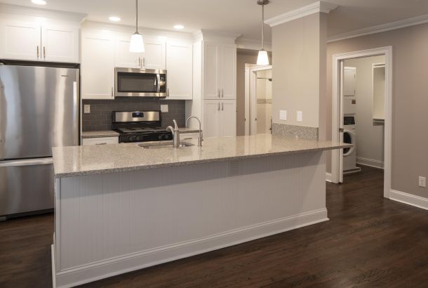 Hickory Manor Modern kitchen with stainless steel appliances, granite countertop, and adjacent laundry room.