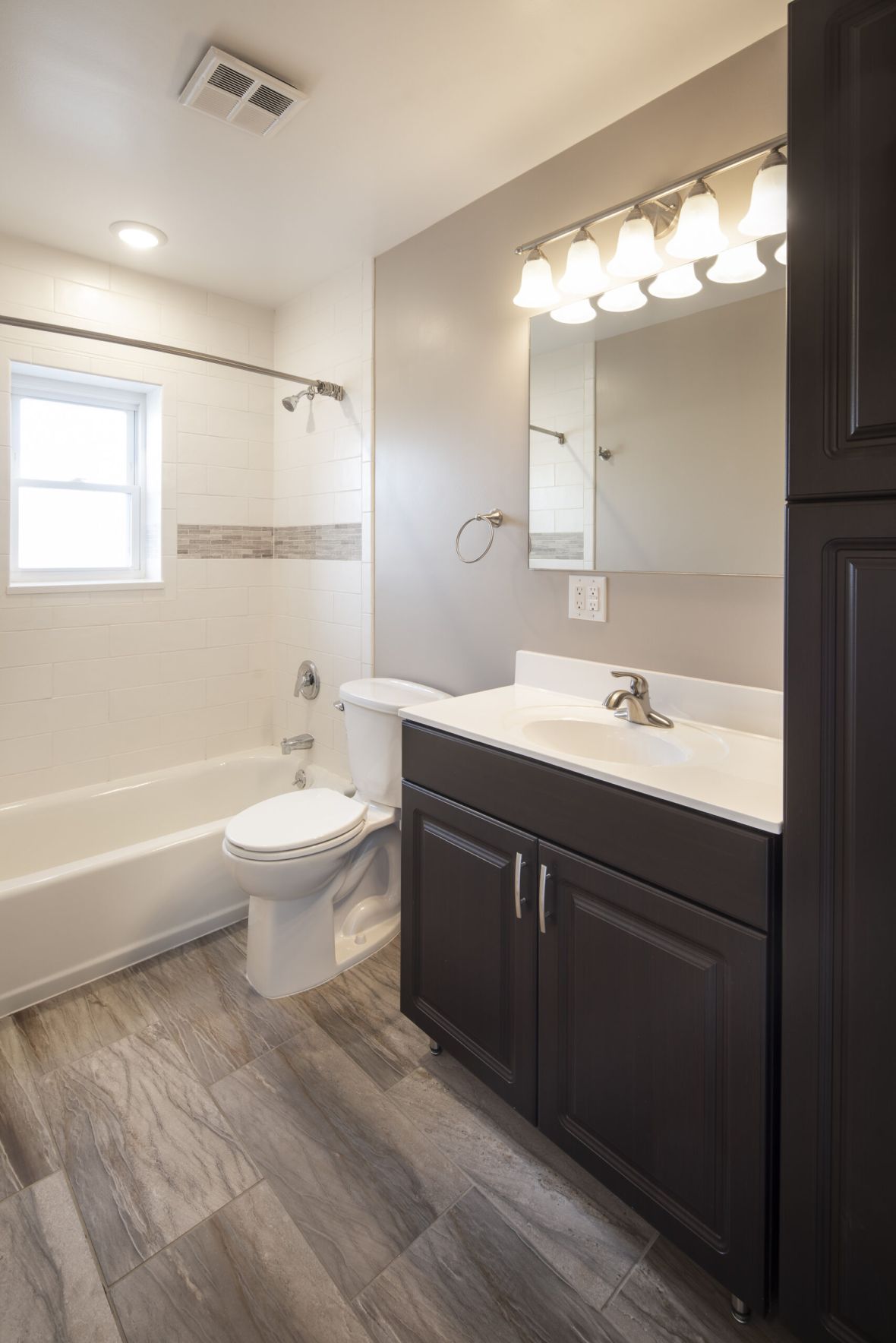 Hickory Manormodern mid-century furnished bedroom with bed, side table, and round mirror