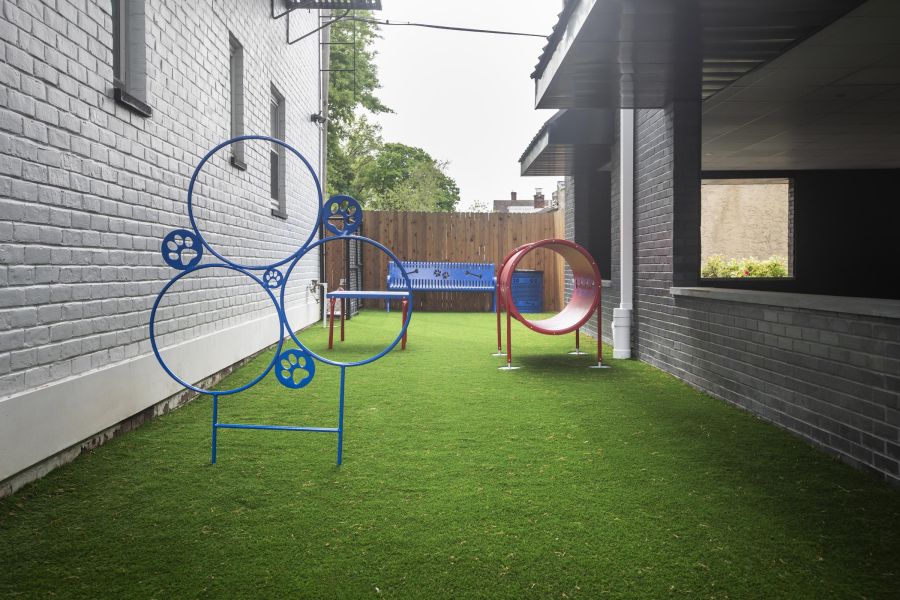 Hickory Manor Two cream chairs and a wooden table with plants and decor against a modern, light wall.