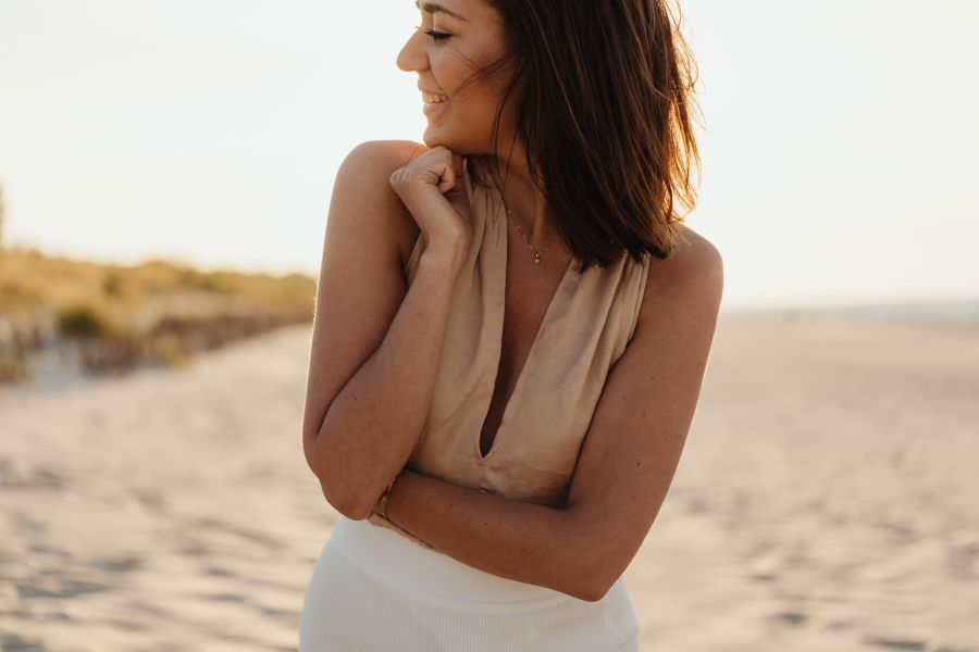Legion Manor Smiling brunette woman on a beach at sunset