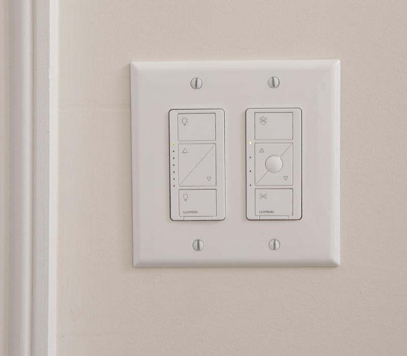 Two white smart switches on a beige wall, each with buttons and small indicator lights.
