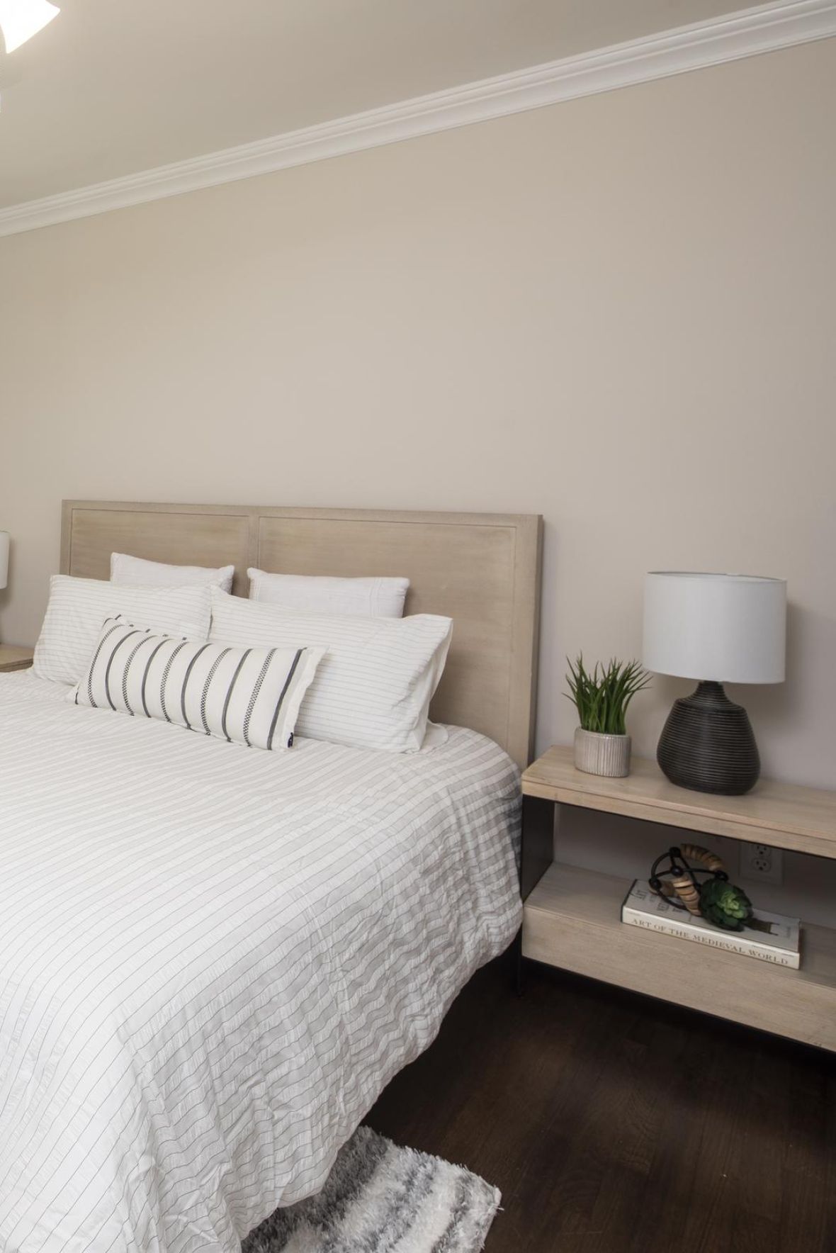 Linden Apartmentsmodern mid-century furnished bedroom with bed, side table, and round mirror