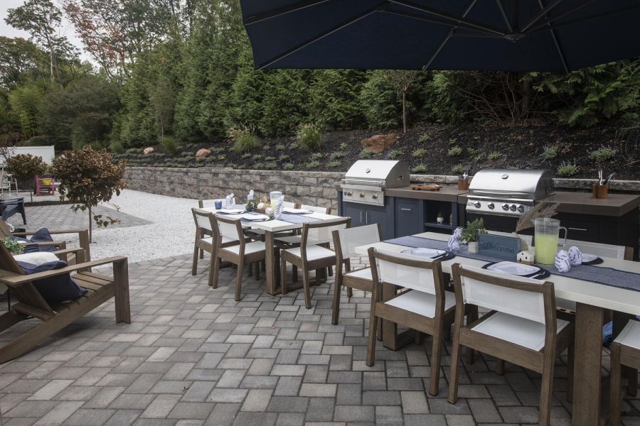 Linden Apartments Checkers game in progress on a wooden table outdoors, with red and black pieces on a fabric board.