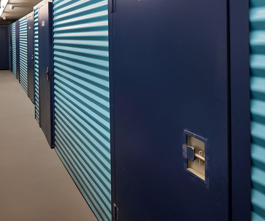 Row of blue storage unit doors in a hallway, with one door labeled "176A2" in the foreground.