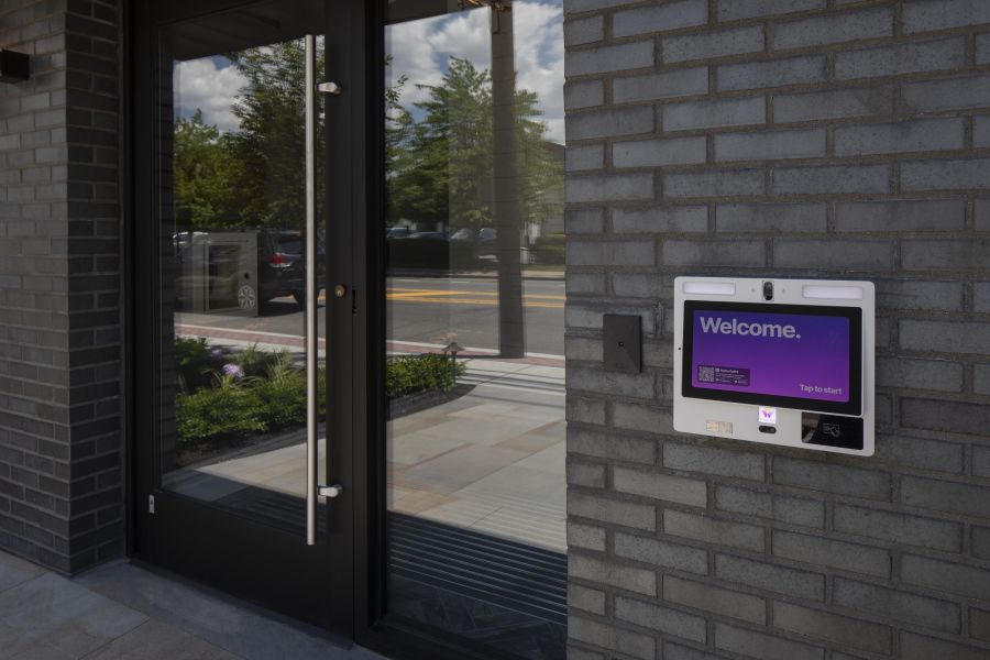 North Washington Square at Hickory A modern apartment building with landscaped gardens and a wooden entrance canopy under a partly cloudy sky.