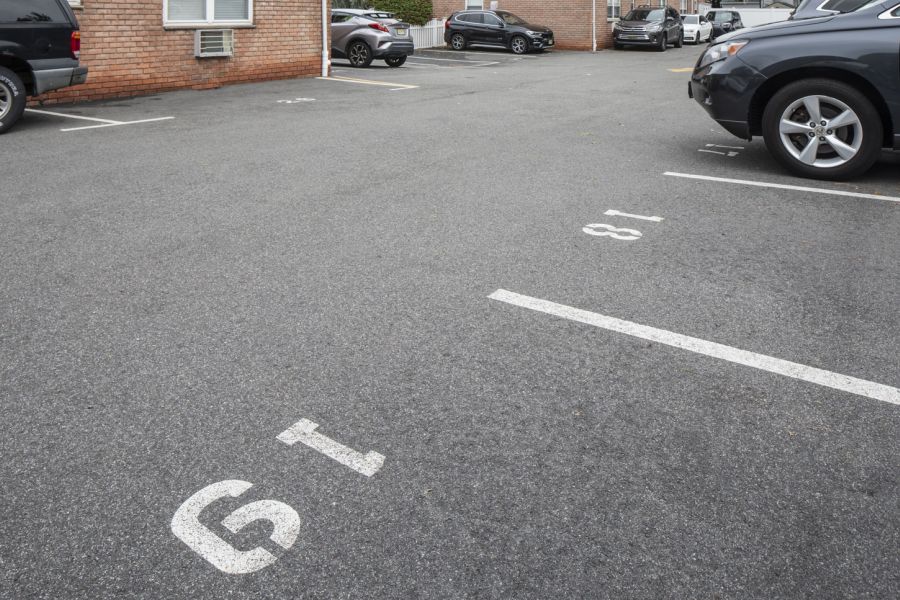 Regency Manor Outdoor patio with wooden pergola, cushioned seating, throw pillows, and a round coffee table with drinks.