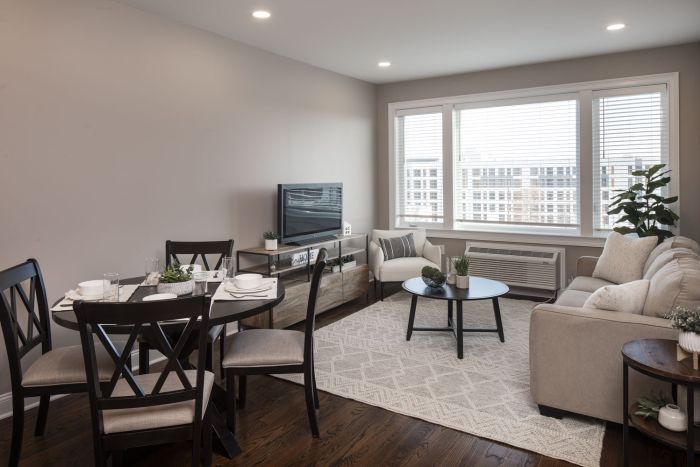 The Atrium Modern living and dining area with neutral tones, large windows, and contemporary furniture.