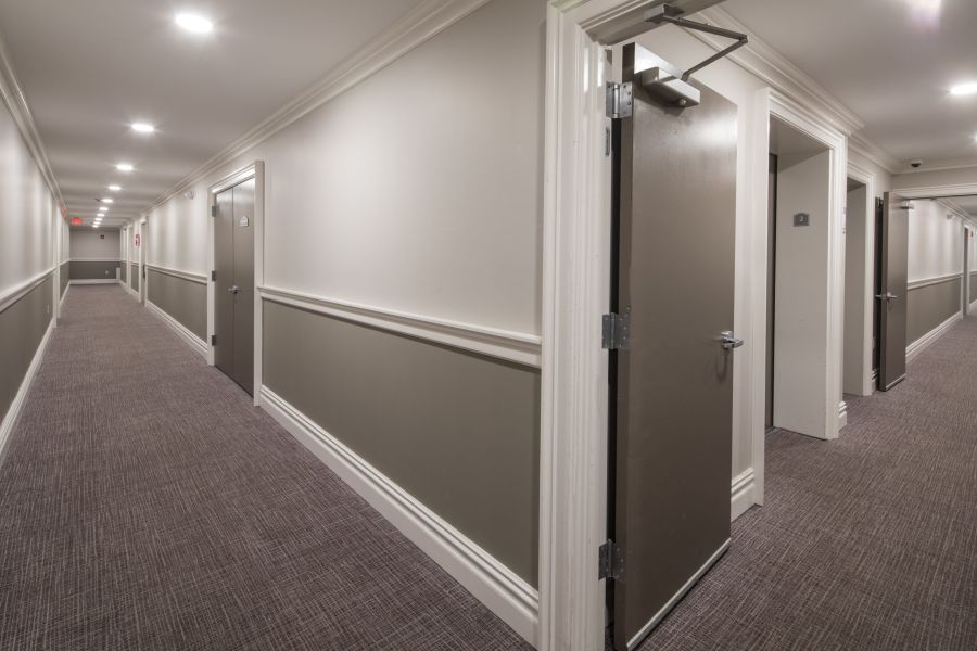 The Atrium Checkers game in progress on a wooden table outdoors, with red and black pieces on a fabric board.