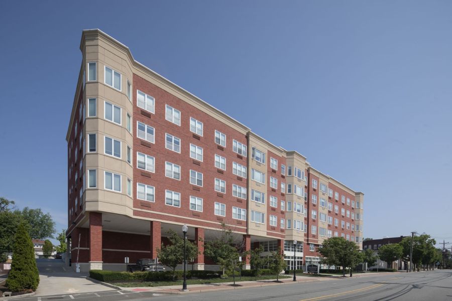 The Atrium Apartment building with black and white exterior, fire escapes, and garages on the ground floor.