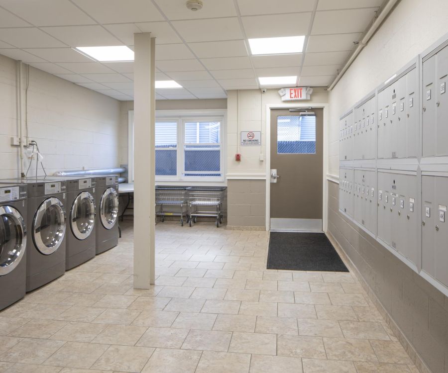 Apartment laundry room with washing machines on the left and mailboxes on the right.