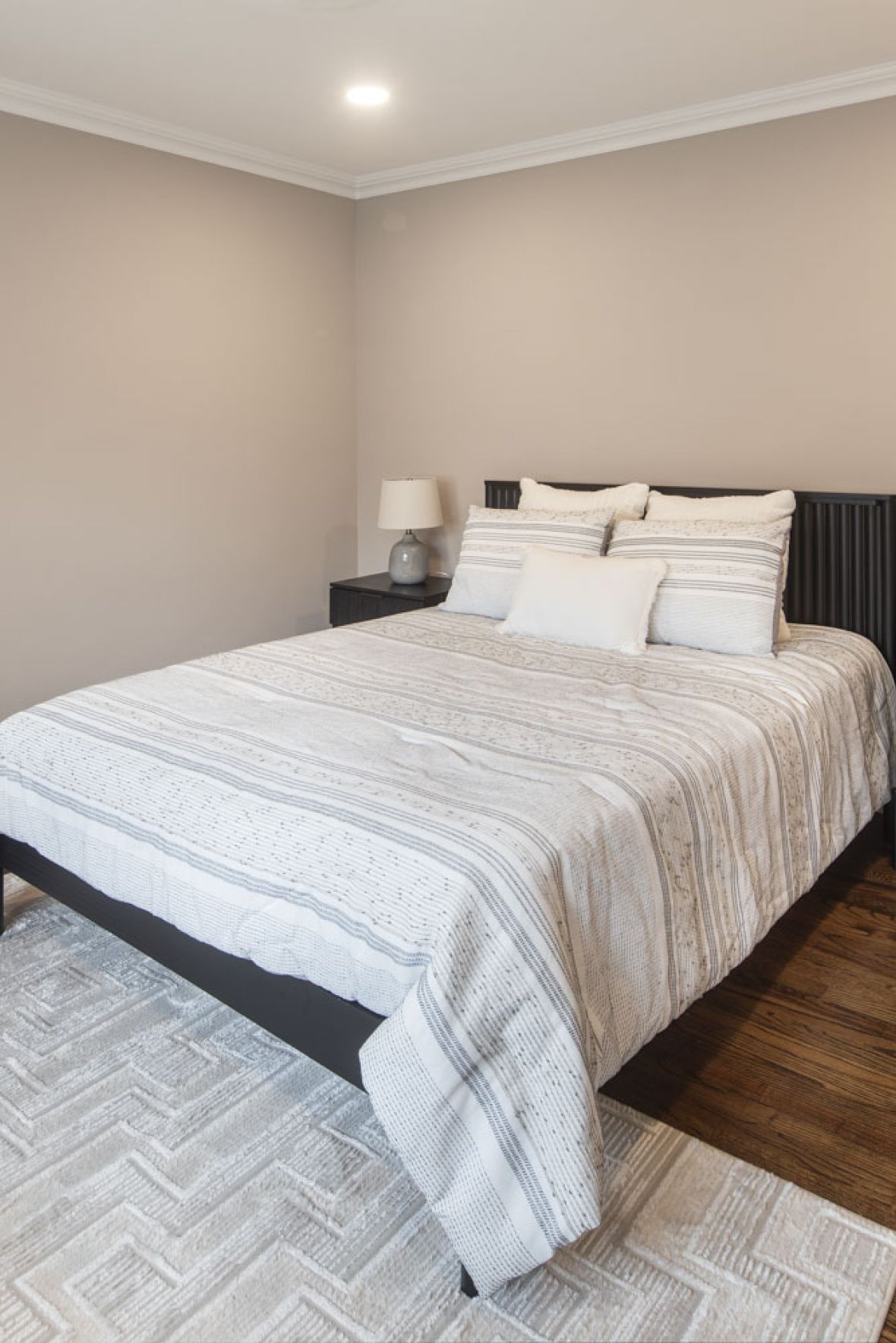 The East Hillmodern mid-century furnished bedroom with bed, side table, and round mirror