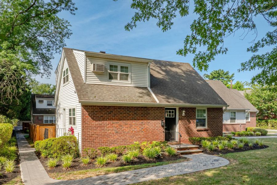 The East Hill Apartment building with black and white exterior, fire escapes, and garages on the ground floor.
