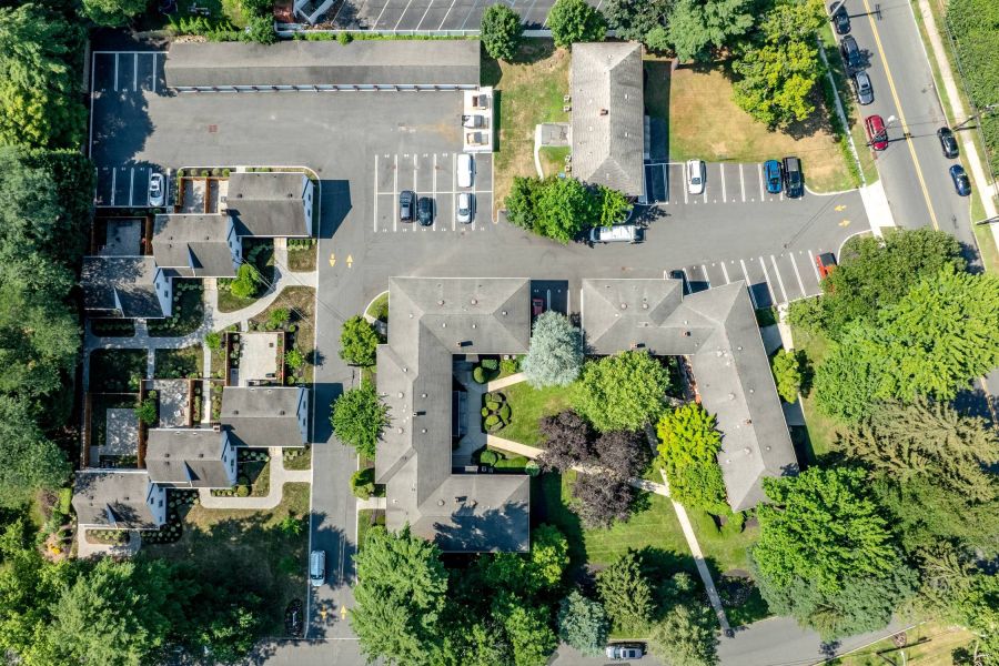 The East Hill A digital ButterflyMX intercom system is mounted on a white brick wall next to a wooden corner.