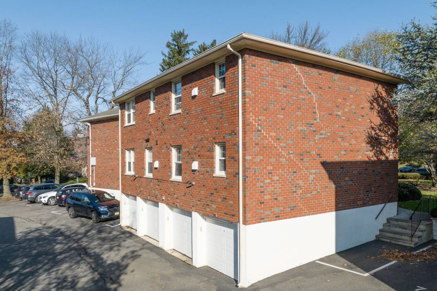 The East Hill Checkers game in progress on a wooden table outdoors, with red and black pieces on a fabric board.