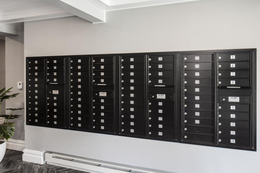 The Parkview @ Polifly Small package room with shelves, a bulletin board, and packages on the floor and shelf.