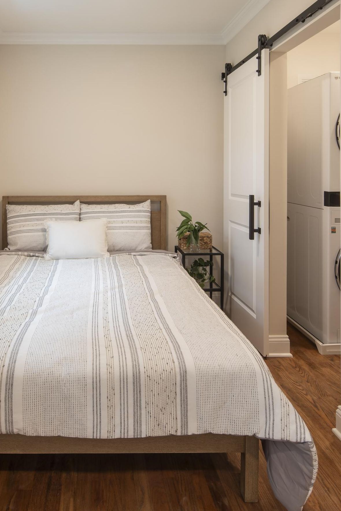 The Parkview @ Poliflymodern mid-century furnished bedroom with bed, side table, and round mirror