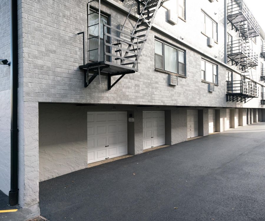 Villa Malta Apartment building exterior with garages below and metal fire escape stairs on the side.