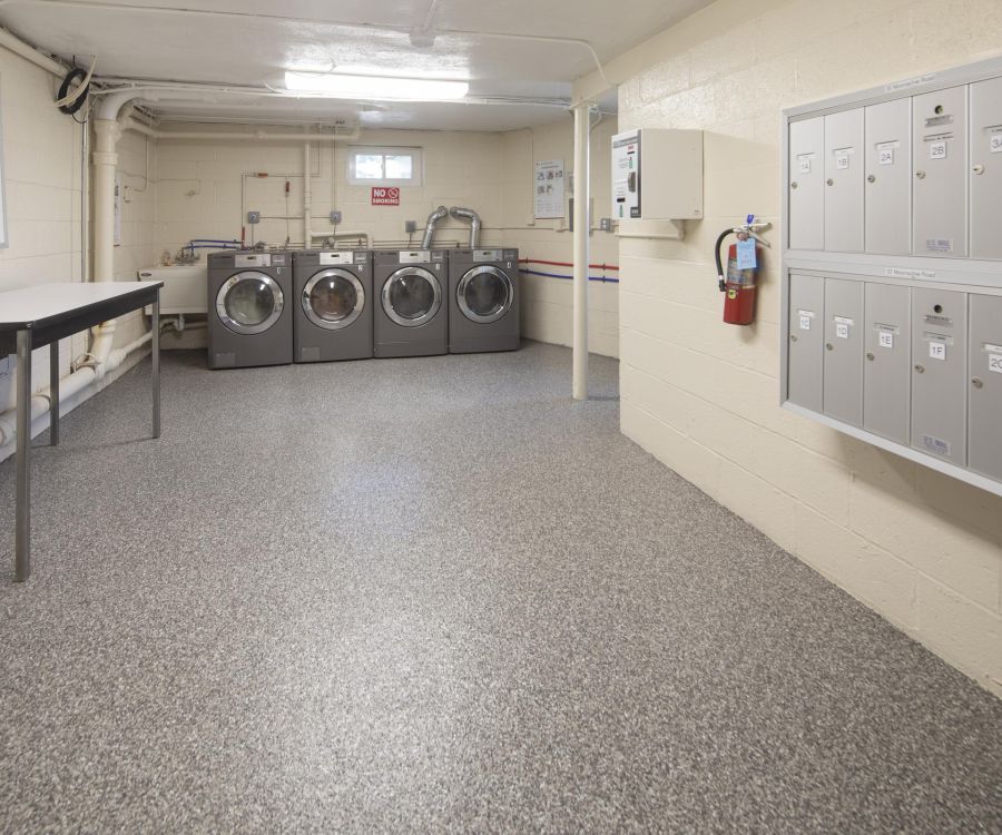 Villa Malta A clean laundry room with three washers, two dryers, a folding table, and a wall of mailboxes.