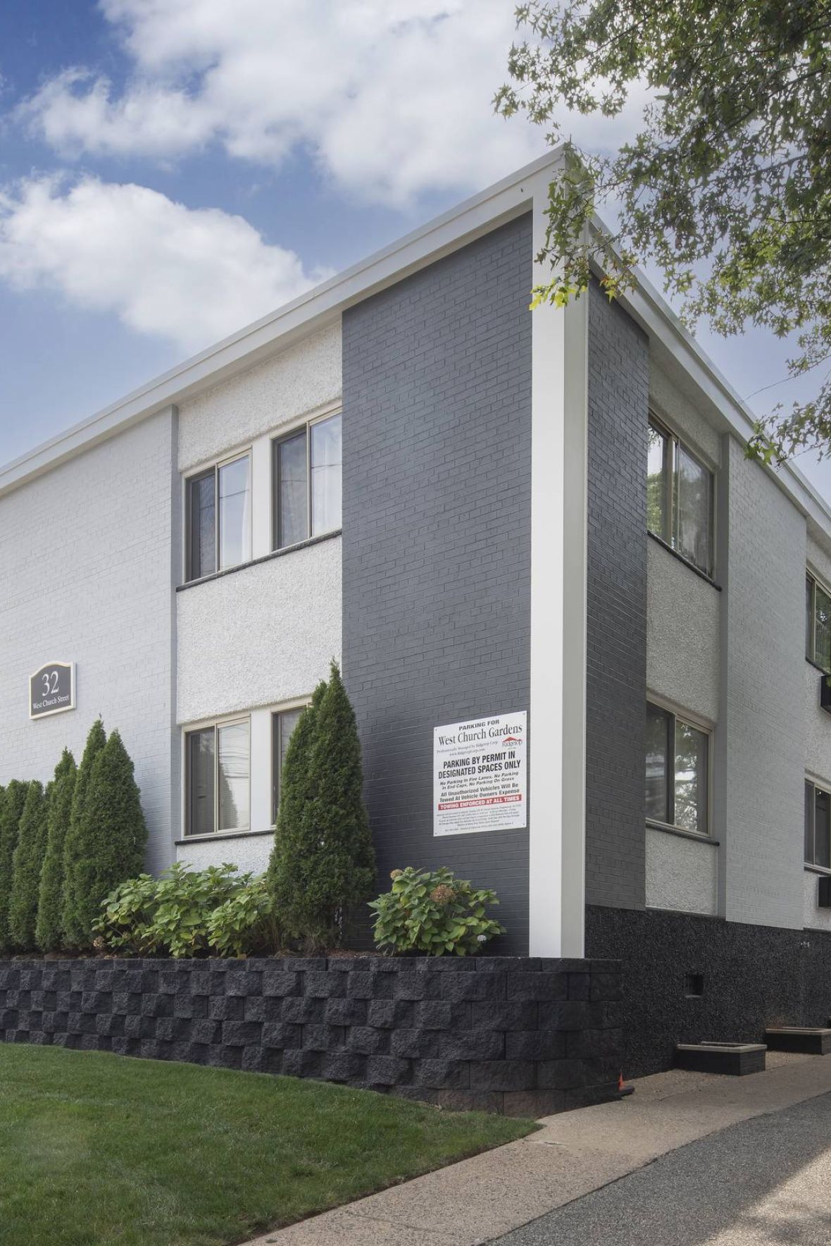 West Church Gardens A vintage clock stands in a plaza with blooming trees and a domed building in the background.