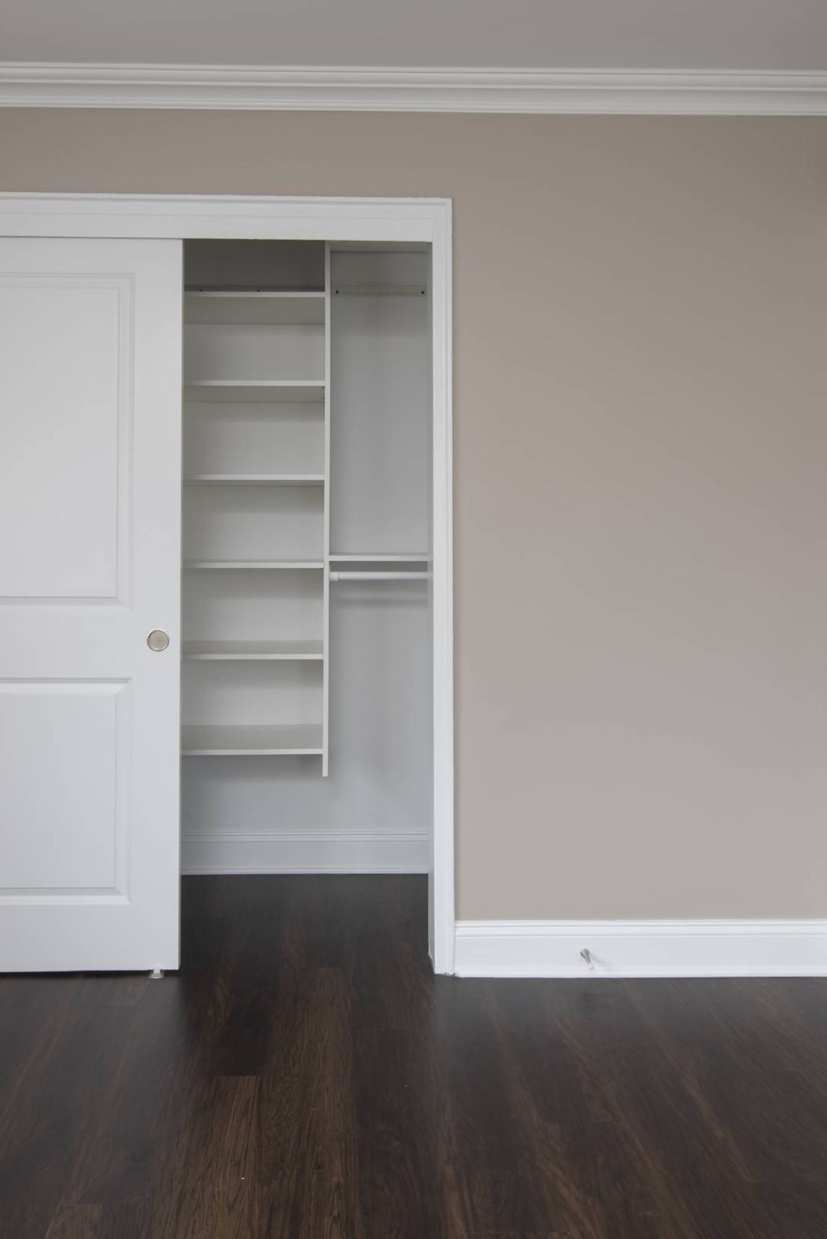 West Church Gardensmodern mid-century furnished bedroom with bed, side table, and round mirror
