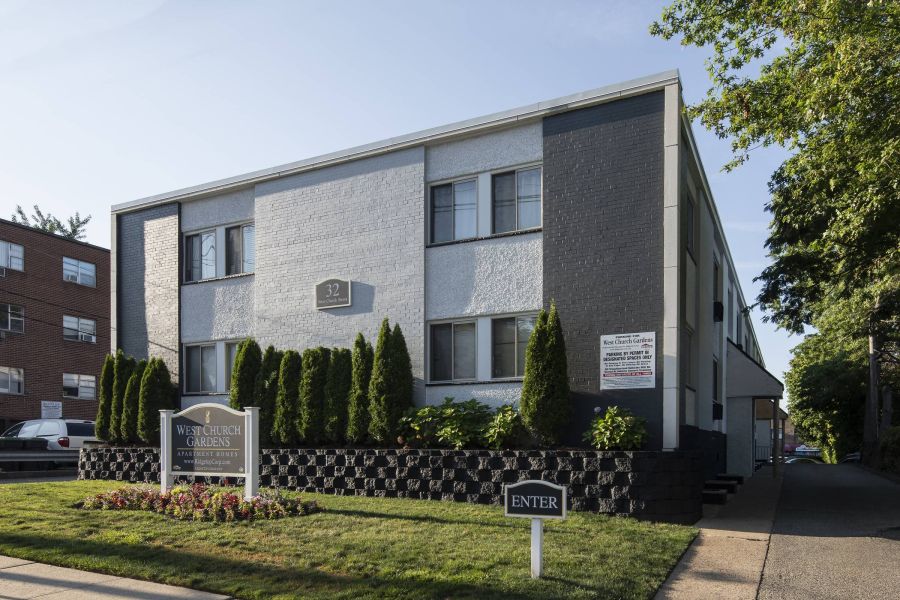 West Church Gardens Small package room with shelves, a bulletin board, and packages on the floor and shelf.