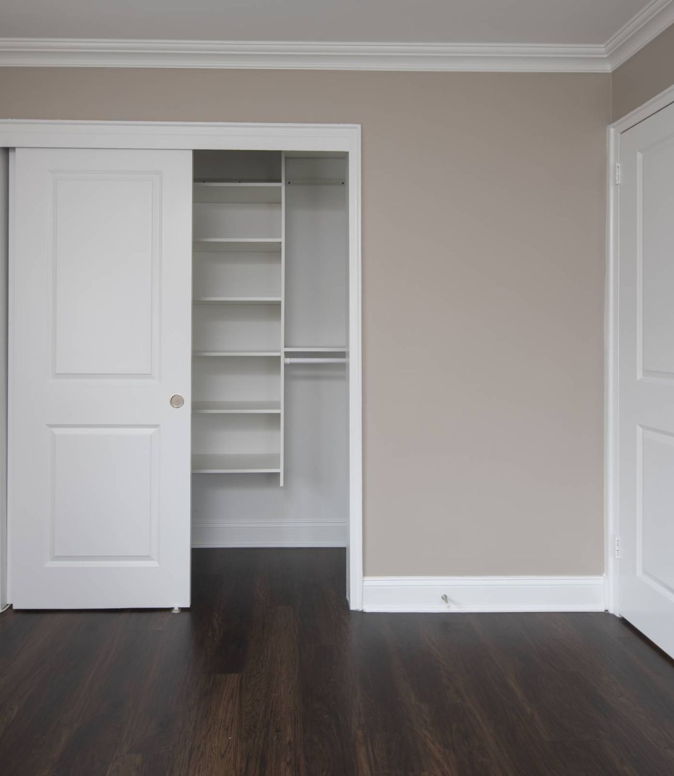 Modern bathroom with dark wood vanity, white countertop, mirror cabinet, and bathtub with white shower curtain.