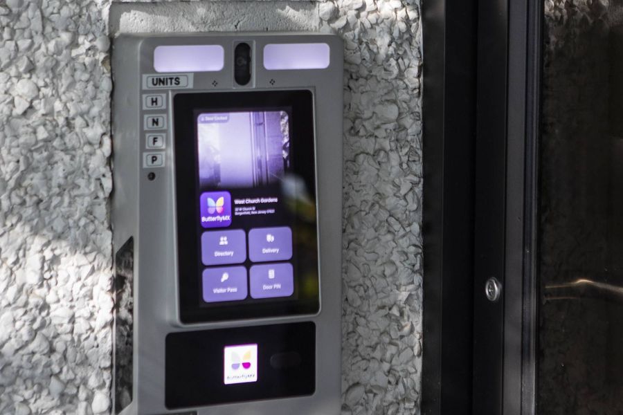 West Church Gardens A modern apartment building with landscaped gardens and a wooden entrance canopy under a partly cloudy sky.