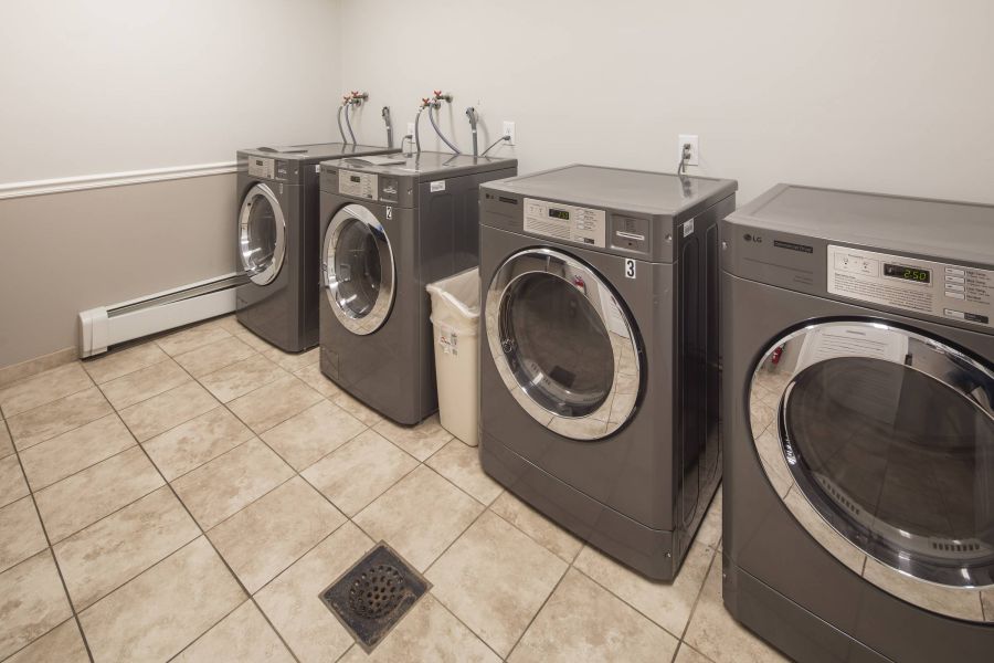 Westwood Manor Checkers game in progress on a wooden table outdoors, with red and black pieces on a fabric board.