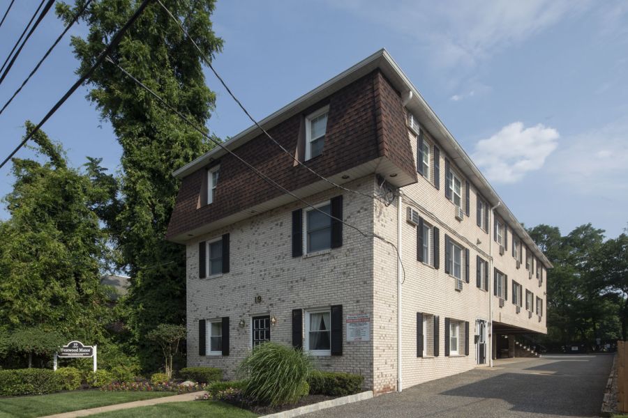Westwood Manor Apartment building with black and white exterior, fire escapes, and garages on the ground floor.