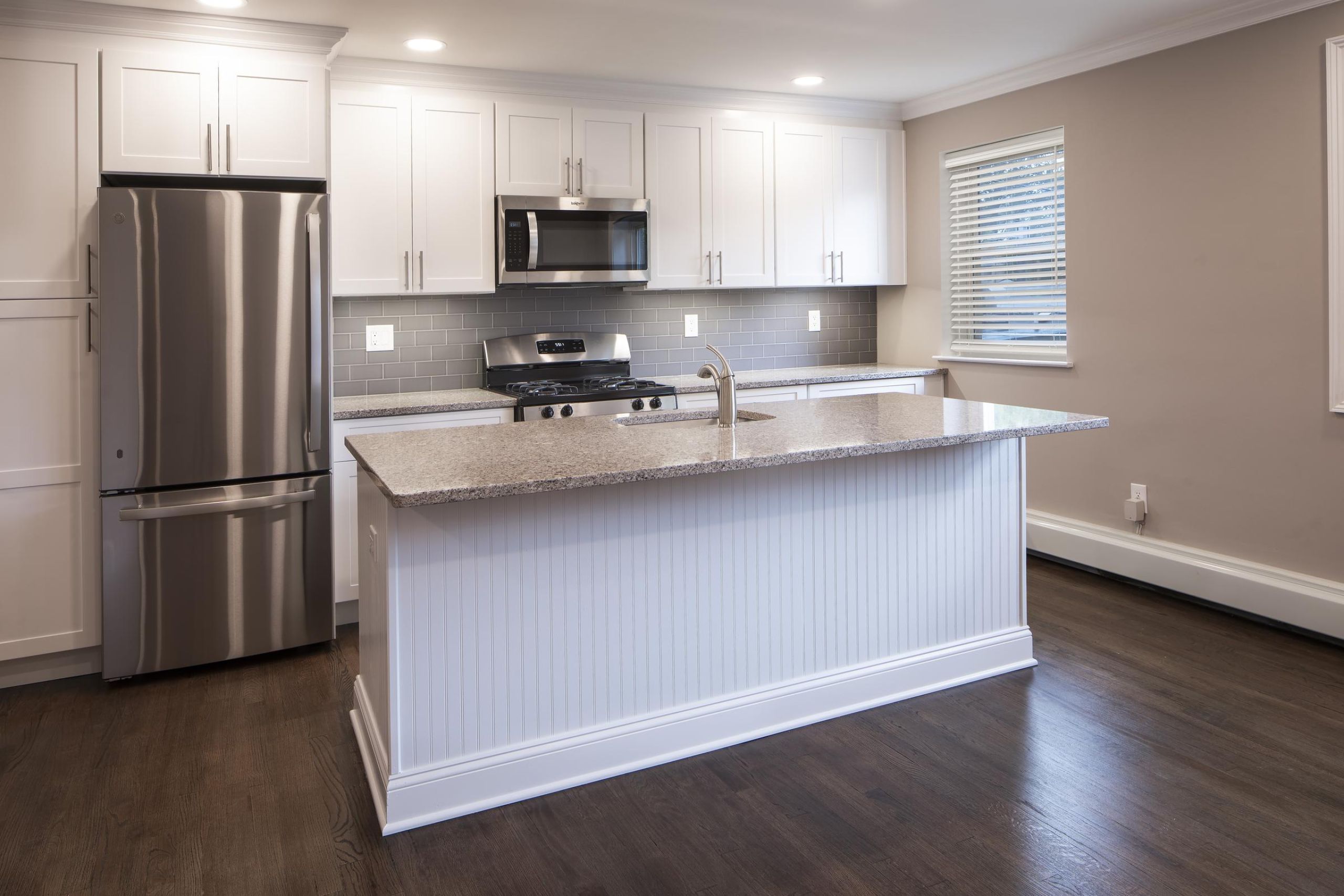 Woodland Hills ManorPatio with wooden pergola, outdoor seating, chairs, and plants, overlooking a green lawn with flags.