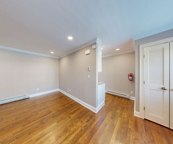 Bright room with hardwood floors, beige walls, recessed lighting, and a closet with white louvered doors in Regency Manor.