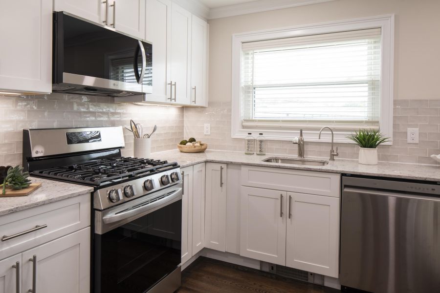 Ridgetop Modern kitchen with white cabinets, stainless steel appliances, and a window above the sink.